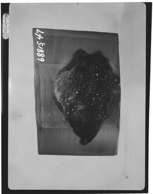 Black and white photograph of Apollo 16 Sample(s) 68815,47; Thin Section photograph displaying a potted butt using reflected light.