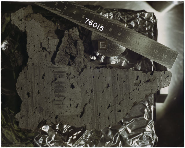 Color photograph of Apollo 17 Sample(s) 76015; Processing photograph displaying slabbing with an orientation of E.