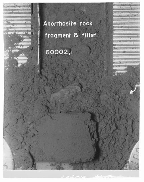Black and white photograph of Apollo 16 Core Sample 60002,1; Processing photograph displaying Core Tube with fragments and fillet of anorthosite rock.