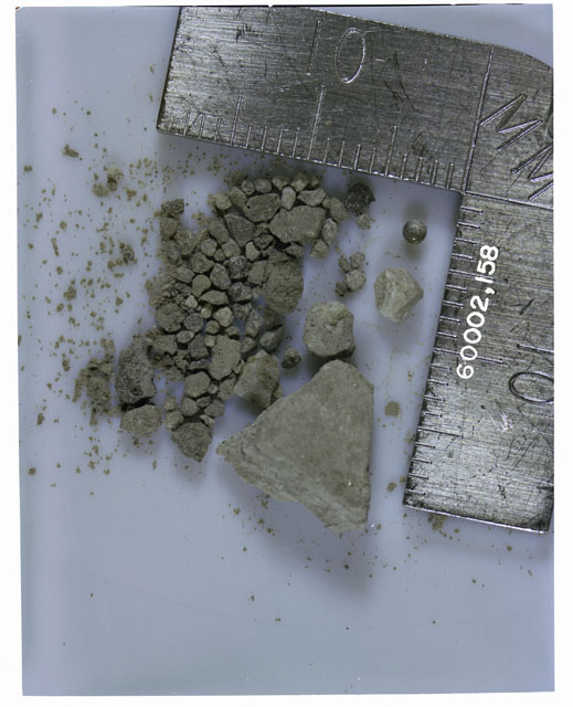 Color photograph of Apollo 16 Core Sample 60002,158; Processing photograph displaying >1 MM Core Fines .