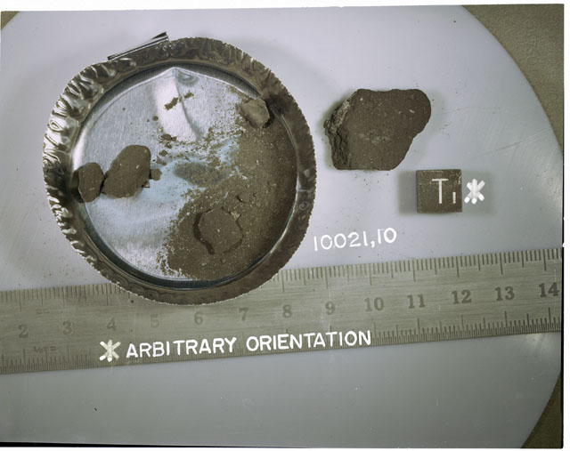 Color photograph of Apollo 11 Sample(s) 10021,10; Processing photograph dispalying a post chip sample with fines and an arbitrary orientation of T.