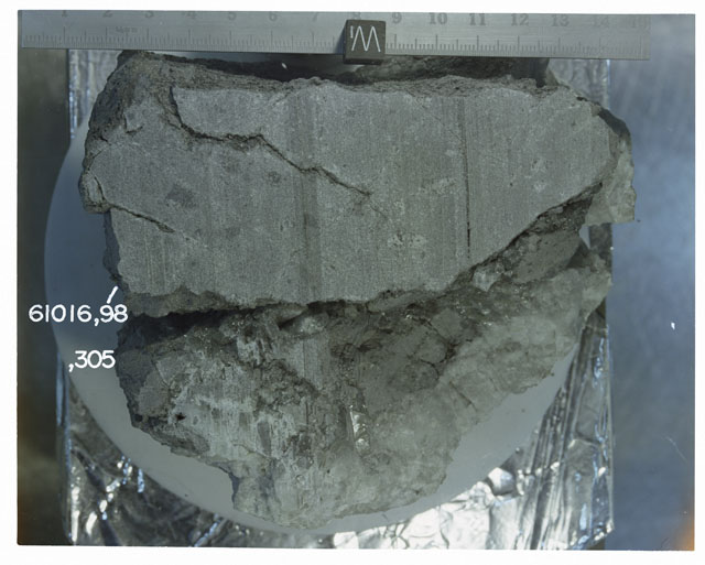 Color photograph of Apollo 16 Sample(s) 61016,98,305; Processing photograph displaying sawed surface reconstruction.