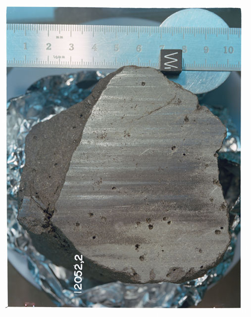 Color photograph of Apollo 12 Sample(S) 12052,2; Processing photograph displaying a sawed surface with an orientation of W.