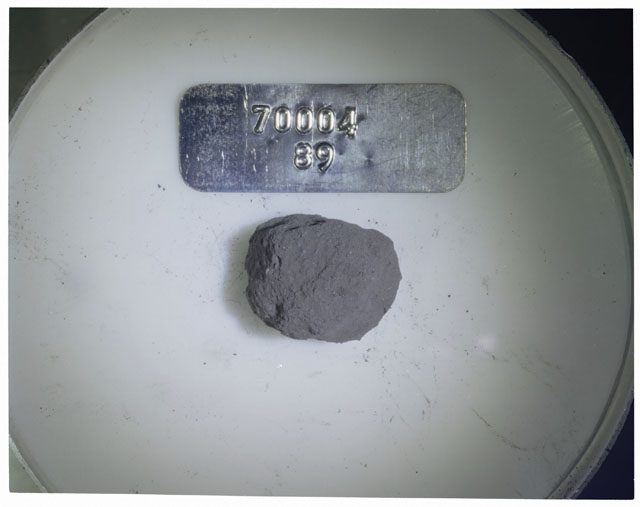 Color photograph of Apollo 17 Sample(s) 70004,89; Processing photograph displaying a group of >1 MM Core Fines found at 184.1-185.7 cm depth from surface.