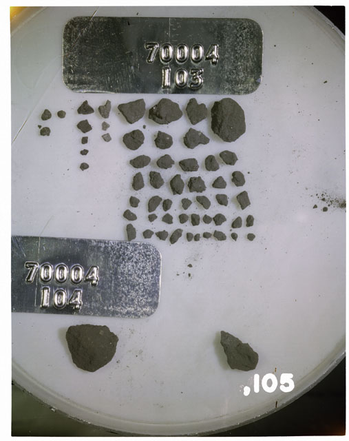 Color photograph of Apollo 17 Sample(s) 70004,103,104,105; Processing photograph displaying a group of Soil Breccias Core Fines found at 186.6-187.2 cm depth from surface.