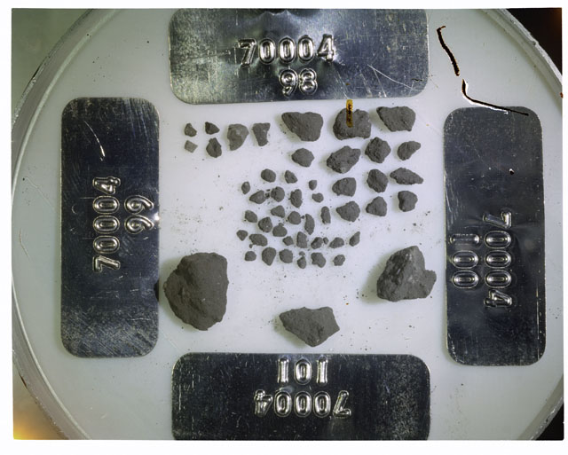 Color photograph of Apollo 17 Sample(s) 7000498-101; Processing photograph displaying a group of >1 MM Core Fines found at 186.7-187.2 cm depth from surface.