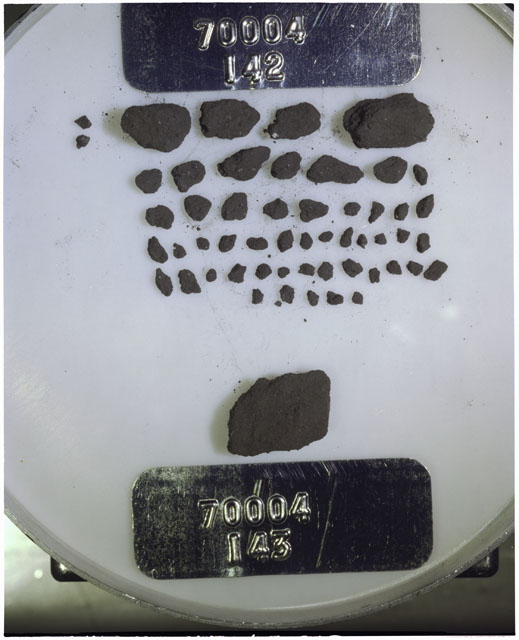 Color photograph of Apollo 17 Sample(s) 70004,142,143; Processing photograph displaying a group of >1 MM Core Fines found at 193.7-194.2 cm depth from surface.