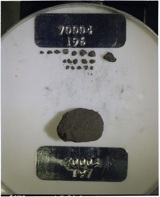 Color photograph of Apollo 17 Sample(s) 70004,196,197; Processing photograph displaying a group of >1 MM Core Fines found at 204.2-204.7 cm depth from surface.