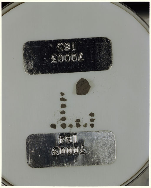 Color photograph of Apollo 17 Sample(s) 70003,184,185; Processing photograph displaying a group of >1 MM Core Fines found at 249.2-249.7 cm depth from surface.