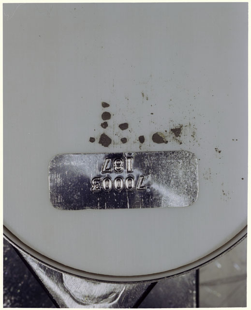 Color photograph of Apollo 17 Sample(s) 70003,187; Processing photograph displaying a group of >1 MM Core Fines found at 249.7-250.2 cm depth from surface.