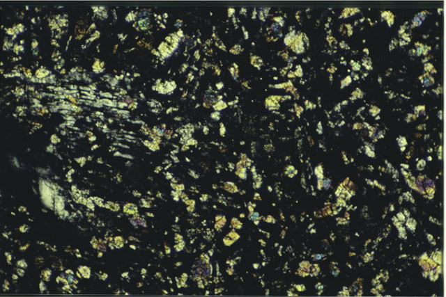 Color photograph of Apollo 16 Sample(s) 61016,220; 2.7 MM Thin Section photograph using cross nichols light.