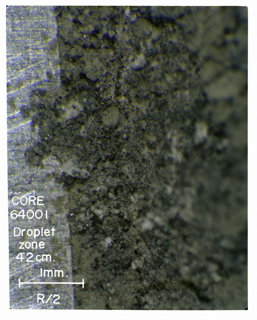 Color photograph of Apollo 16 Core Sample(s) 64001; Processing photograph displaying Core with droplet zone.