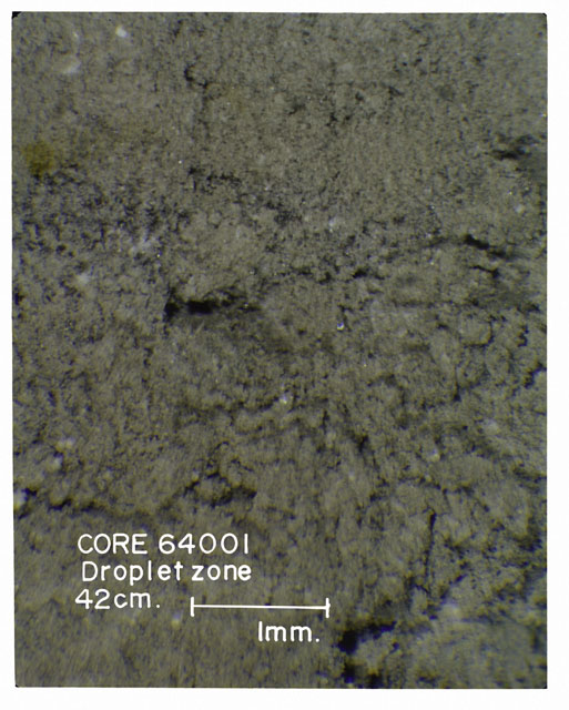 Color photograph of Apollo 16 Core Sample(s) 64001; Processing photograph displaying Core with droplet zone.