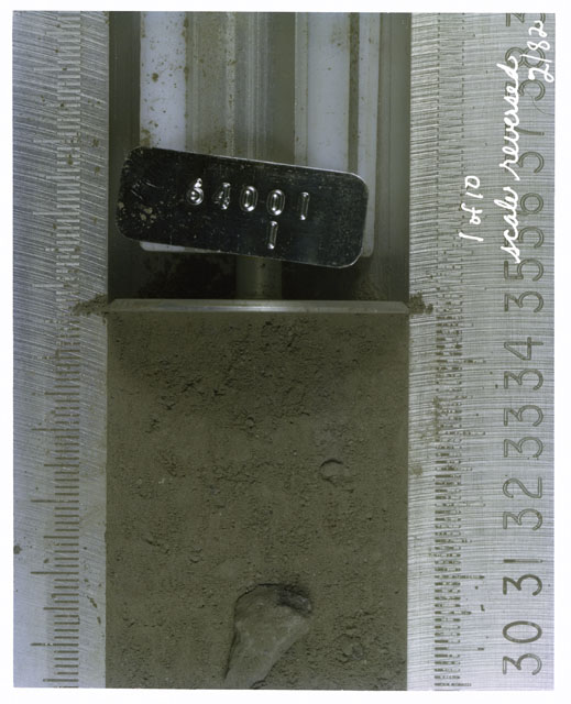 Color photograph of Apollo 16 Core Sample(s) 64001,1; 1 of 10 Processing photograph of displaying Core with scale reversed.