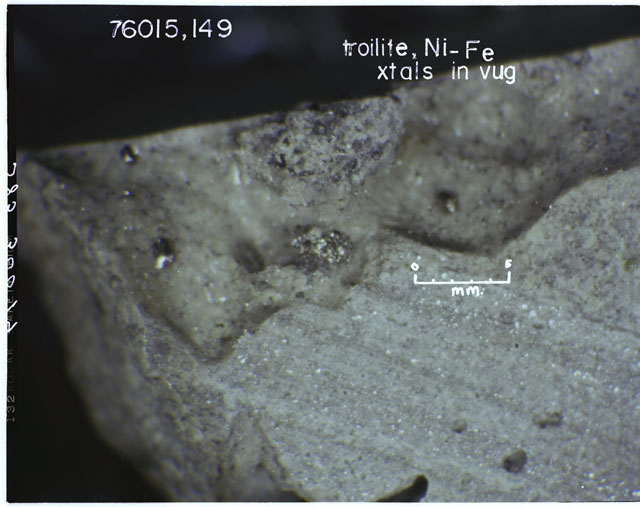Color photograph of Apollo 17 Sample(s) 76015,149; Processing photograph displaying a close up view of Troilite and Ni-Fe crystal VUG.