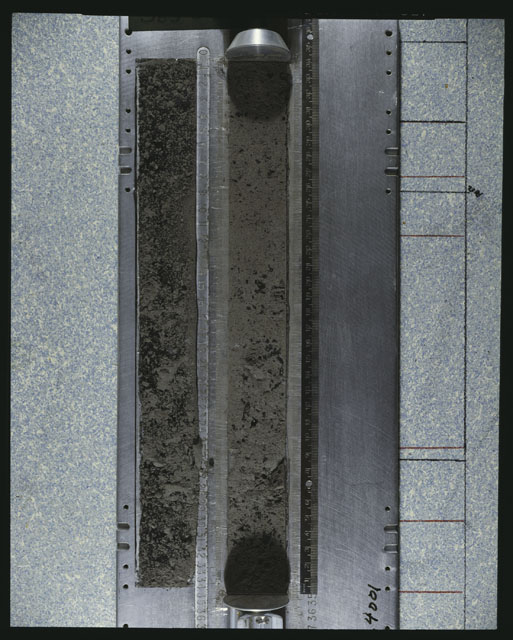 Color photograph of Apollo 16 Core Sample 64001; Processing photograph displaying an overview of the Core core with peel.