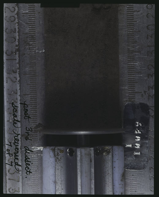 Color photograph of Apollo 16 Core Sample(s) 64001; 7of 7 Processing photograph displaying post 3rd dissection Core with the scale reversed.