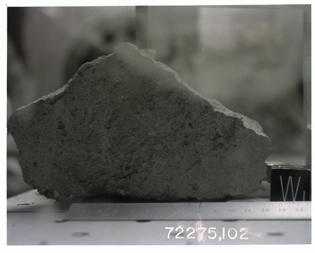 Color photograph of Apollo 17 Sample(s)72275,102; Processing photograph displaying sawed surface with an orientation of W.
