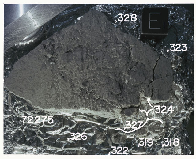 Color photograph of Apollo 17 Sample(s)72275,318,319,322-324,326-328; Processing photograph displaying slab reconstruction with an orientation of E.