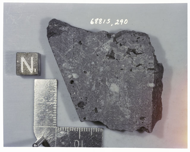 Color photograph of Apollo 16 Sample(s) 68815,290; Processing photograph displaying sawed surface with an of N.