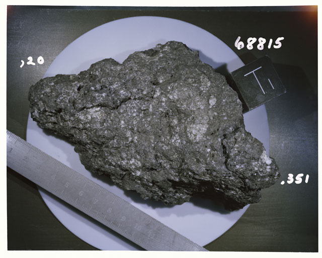 Color photograph of Apollo 16 Sample(s) 68815,20,351; Processing photograph displaying reconstruction with an of T.