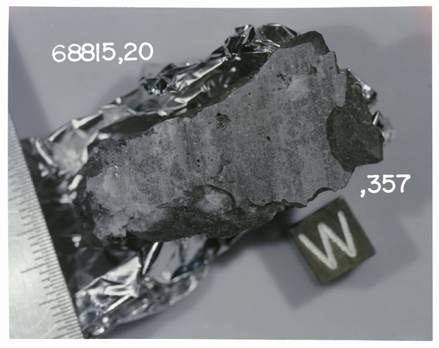 Color photograph of Apollo 16 Sample(s) 68815,20,357; Processing photograph displaying sawed slab with an orientation of W.