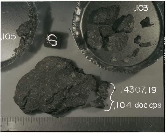 Color photograph of Apollo 14 Sample(s) 14307,19,104-105; Processing photograph displaying post chip sample with an orientation of S.